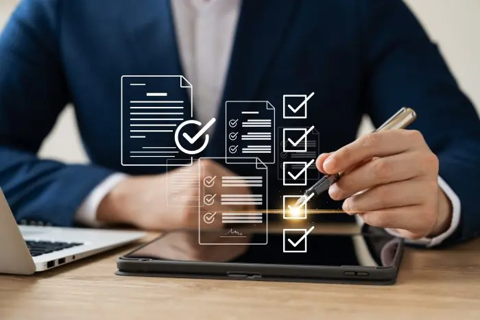 Businessman using a stylus on a tablet with floating checklist and document icons