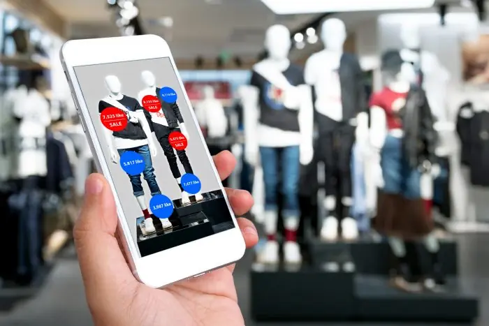 Smartphone showing store mannequins with red and blue like and sale count bubbles in a retail shop