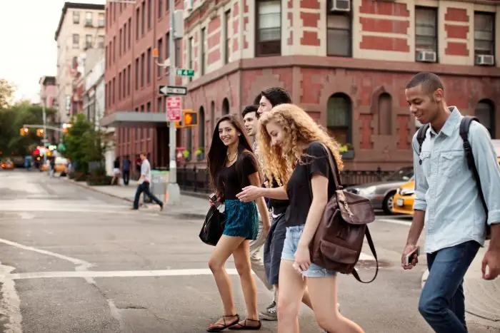 Group of young people walking across a city street